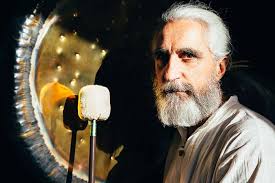 Vikrampal tocando el gong en una sala iluminada por luz dorada – símbolo de maestría sonora y expansión espiritual