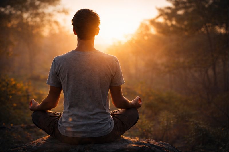 Persona meditando al amanecer con sensación de calma y claridad mental.